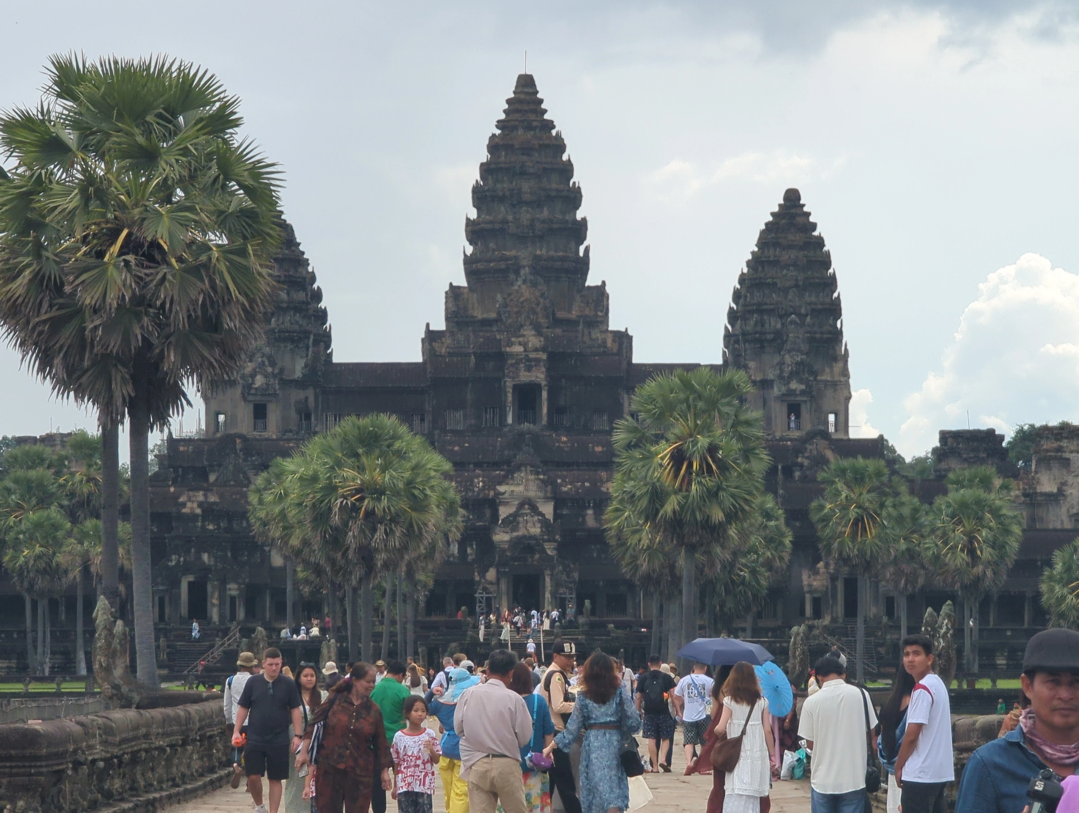 Visitors walking the stone causeway toward Angkor Wat temple in Cambodia